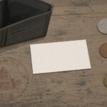 財布と硬貨の横に置かれた一枚の名刺——自腹で作る公務員の名刺を表したイラスト